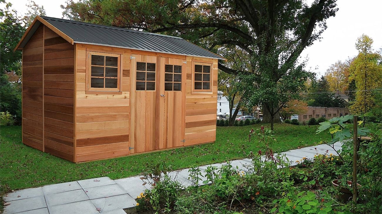 A cedar shed beside a large tree in a grassed area