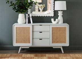 Updated painted dresser decorated with a lamp, vases and books.