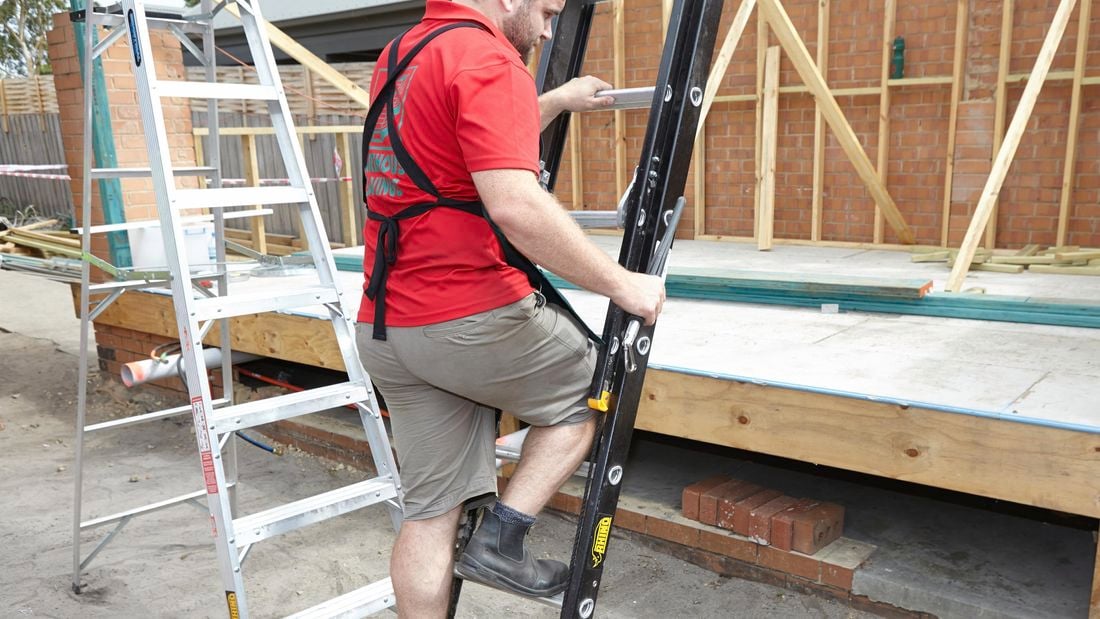 A person climbing a ladder holding a ladder limb