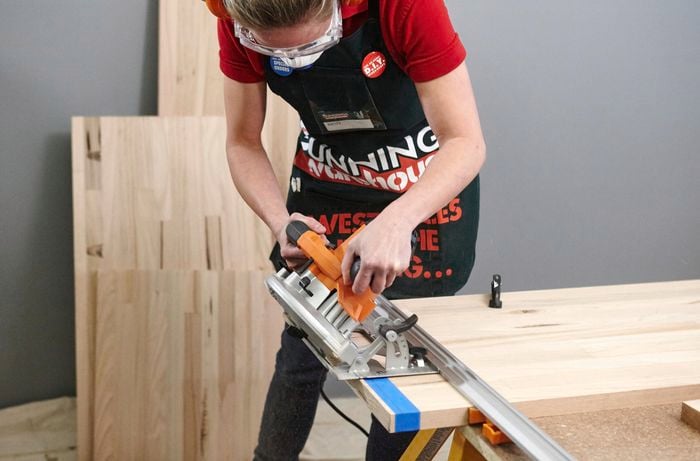 A person cutting a timber panel on a 45 degree angle using a circular saw