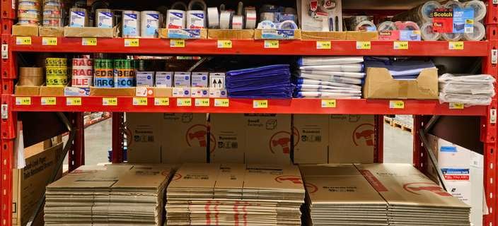 Red Dexion (Shelving) in a Bunnings store with Moving supplies on it.