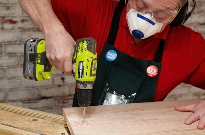 A hole being drilled into a bar counter for a screw