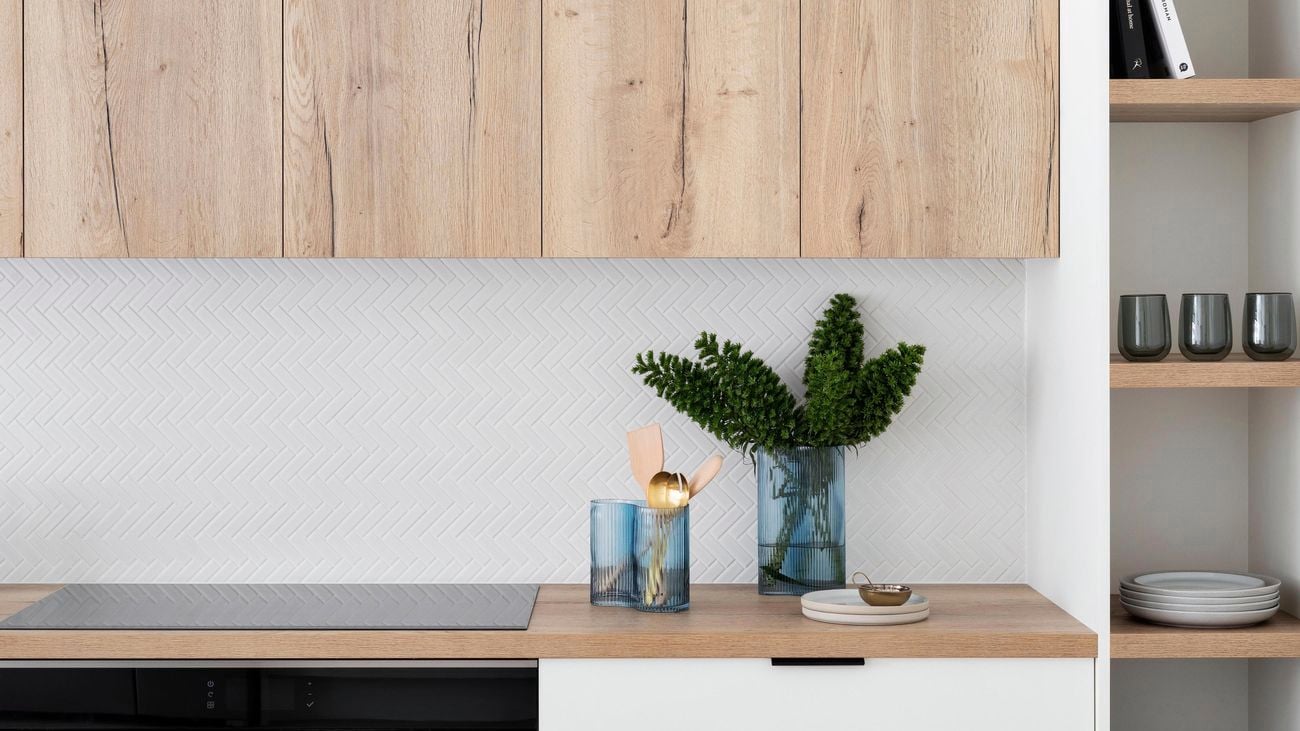 Modern kitchen with wooden cabinets and white tiled splashback