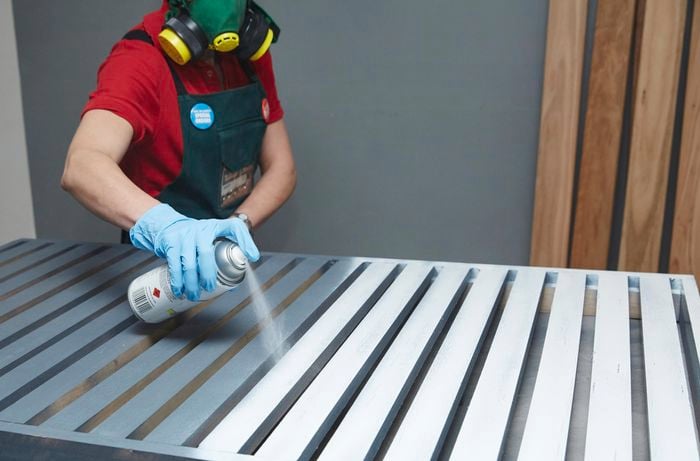 Person spraying tabletop with spray paint