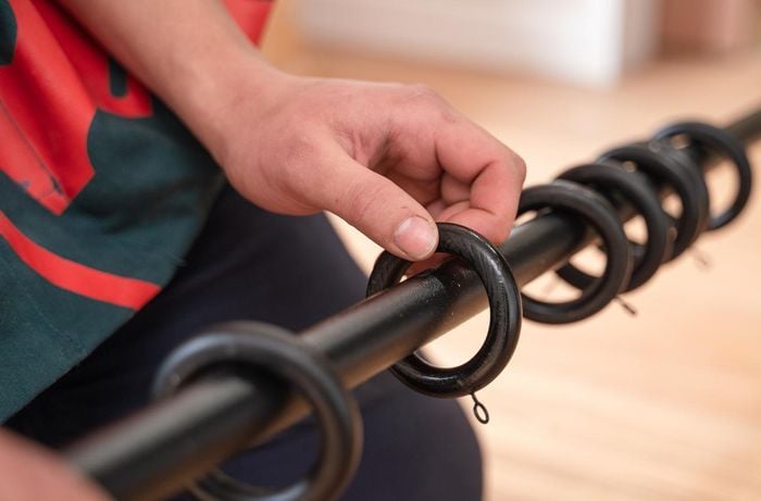 Bunings TM placing rings on a black curtain rod