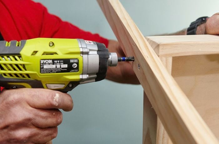 A person joining pieces of timber using a cordless driver