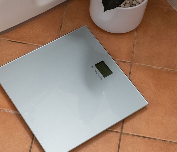 Digital bathroom scales with a small electronic display and white in colour