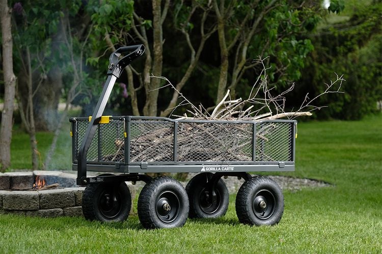 A Gorilla Cart mesh trailer being used to carry dry branches