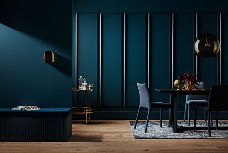 A blue themed dining room with a feature wall