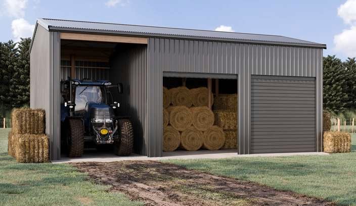 A metal shed with three sections. The left section contains a blue tractor, the middle section is filled with stacked hay bales, and the right section has a closed garage door.