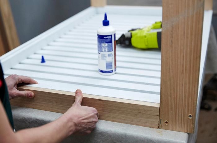 Person attaching trim to edge of coffee table