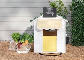 A finished cubby house customised to look like a greengrocer, pictured from the front