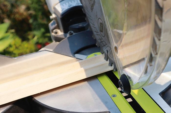Person using drop saw to cut piece of timber