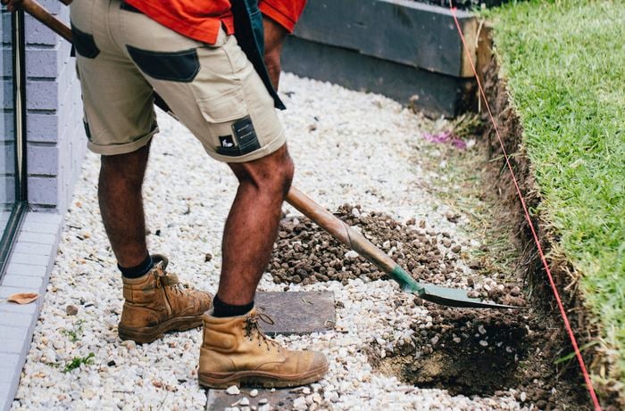 A Bunnings team member digging a posthole