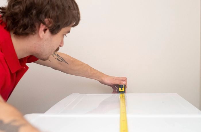 Measuring the dimensions of appliances to calculate the correct size for a laundry benchtop