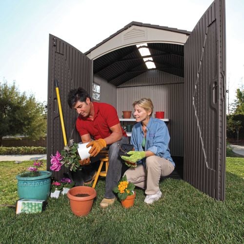 two people potting a cyclamen working out of their small shed