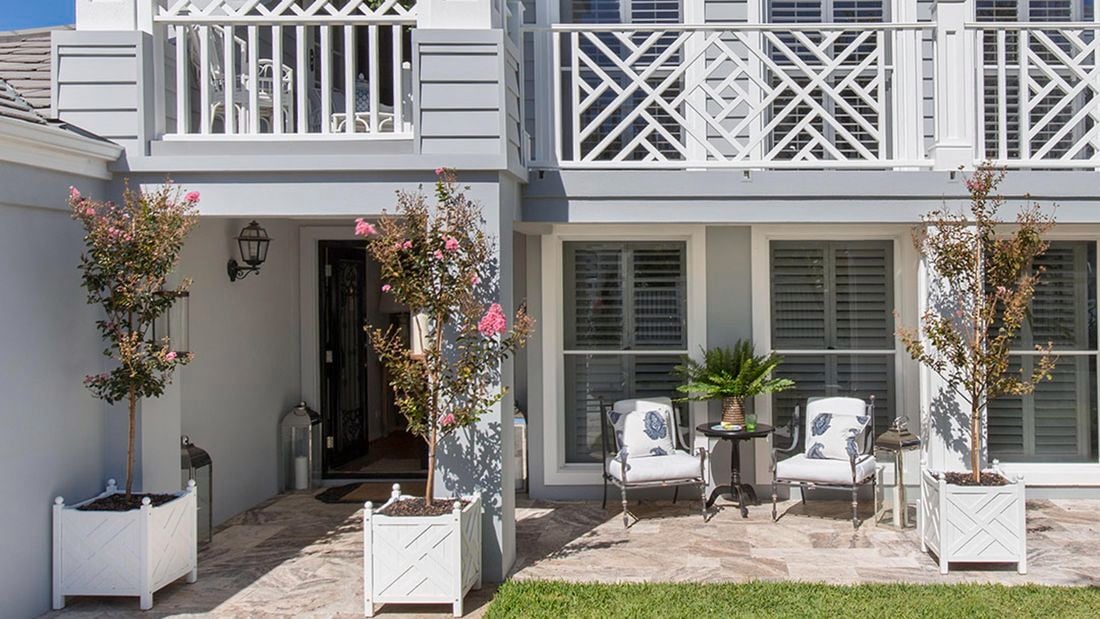The front of a two-storey grey weatherboard home with white trim