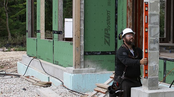 Person using box level to measure level of pillar