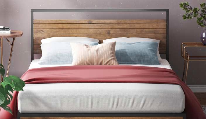 Bed with side tables and a plant on the floor