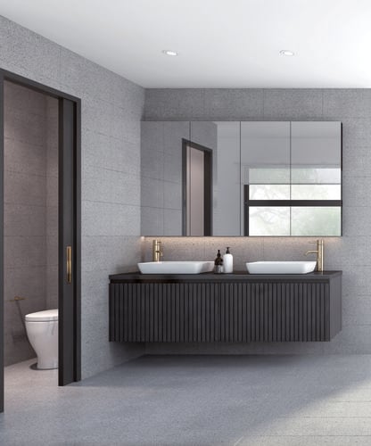 A cool toned bathroom with gold sinks and wooden panelling on the cabinets
