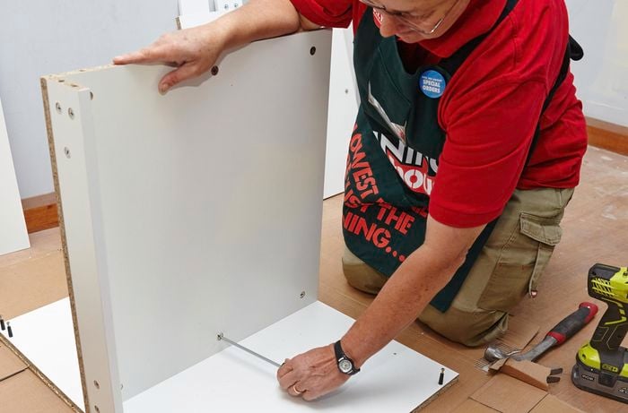Person attaching shelf to side panel