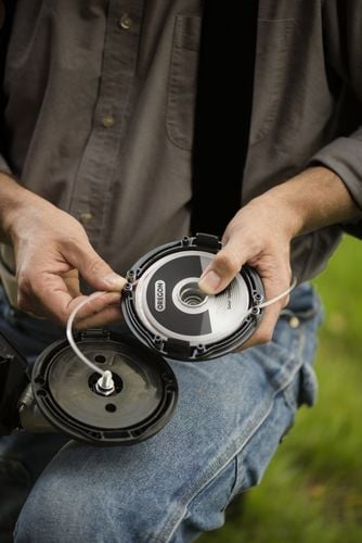 Person replacing wiring in grass clipper