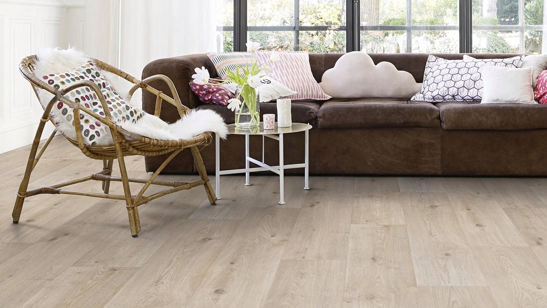 Lounge room with timber flooring, couch and accent chair.