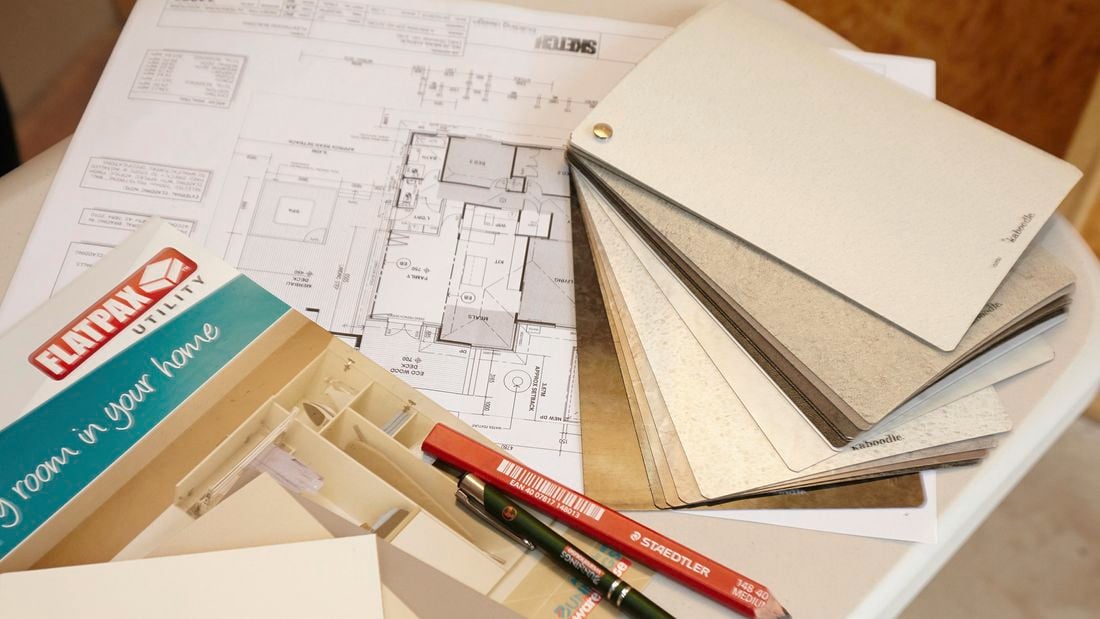 A house floor plan with laminate swatches, a pen and a pencil