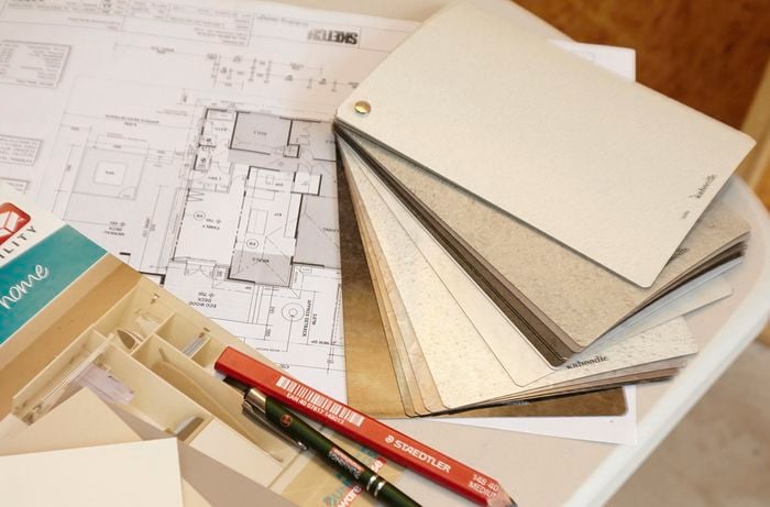 A house floor plan with laminate swatches, a pen and a pencil