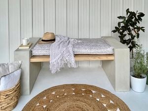 Block bench with timber slats, hat, rug and plant