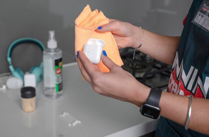 Wiping down the airpods case using microfibre cloth.