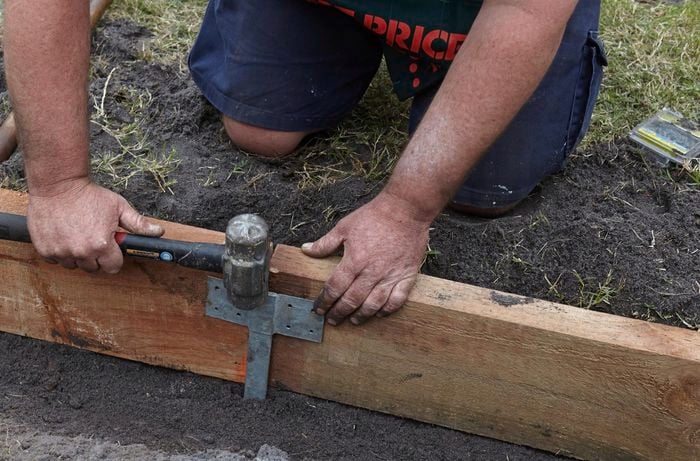 Metal brackets being used to secure two sleepers against each other