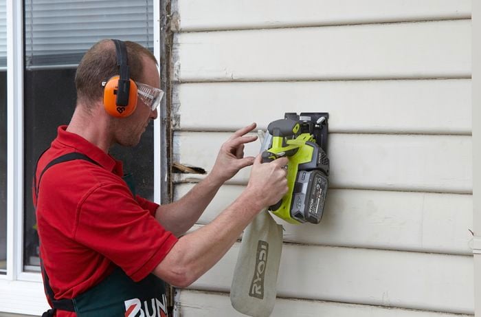 A rotten weatherboard being cut through with a circular saw