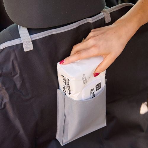 A person placing some pet wipes into a hammock pouch.