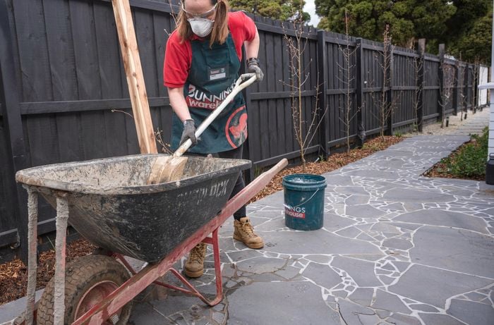 Concrete being mixed in wheelbarrow