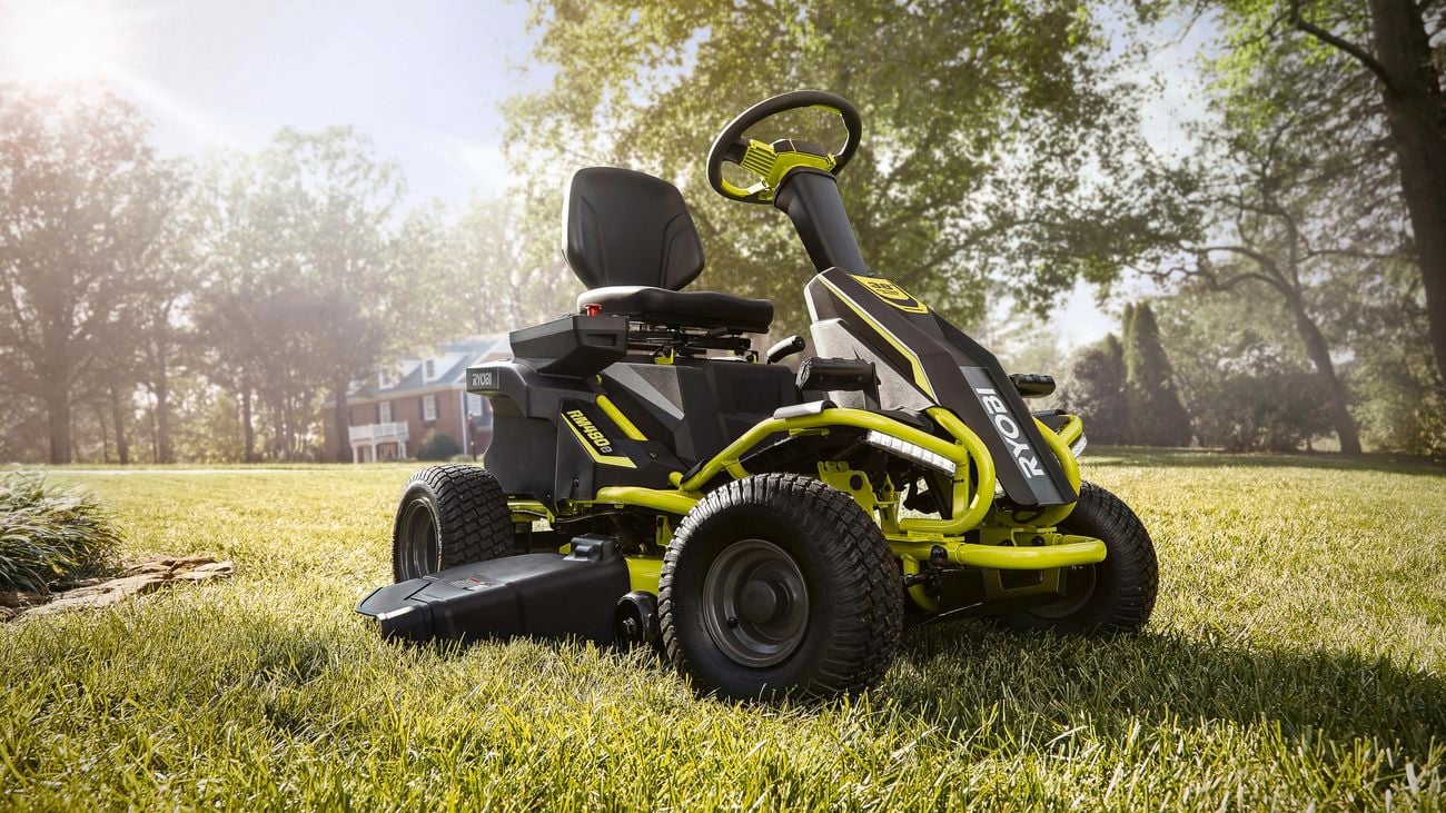 Ryobi ride-on lawn mower parked in a backyard