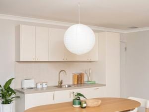 Wireless pendant light with a paper shade installed above a dining table
