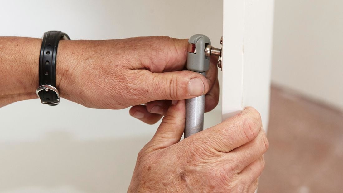 Person attaching gas strut to door.