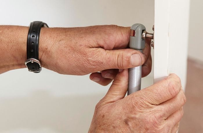 Person attaching gas strut to door.