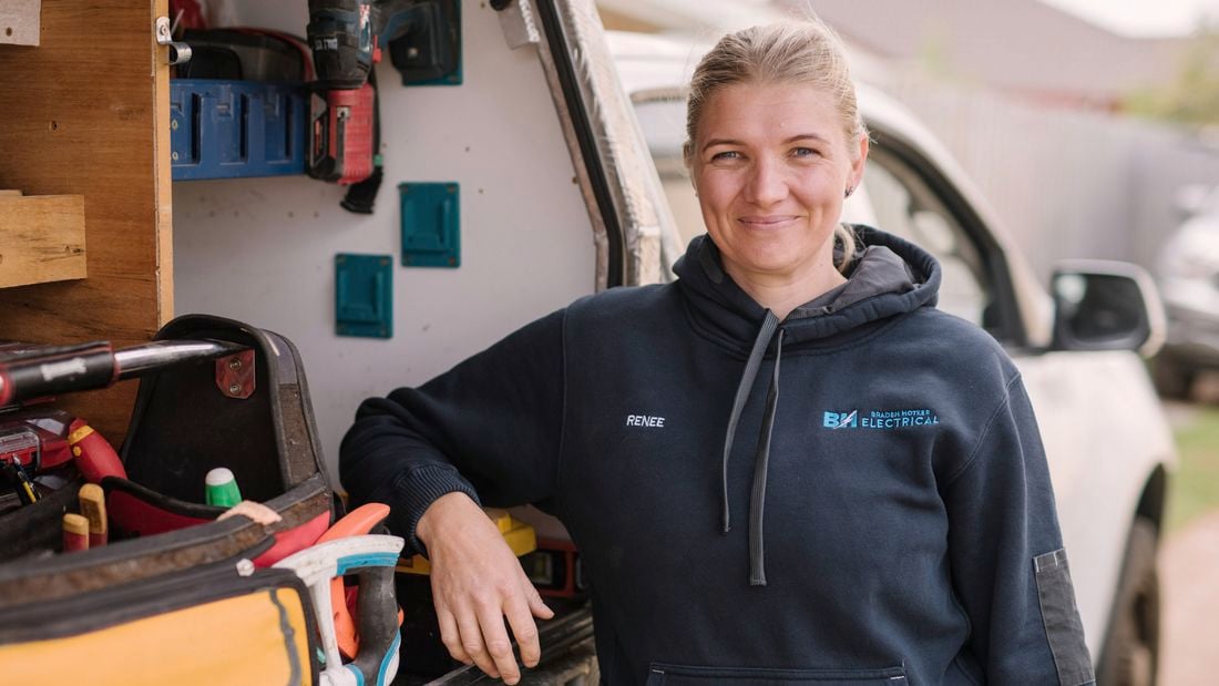 A smiling Women In Apprenticeships Awards winner 2025 Renee Evans stands beside her work ute.