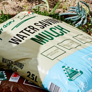 Potting mix bags laid out on a lawn.