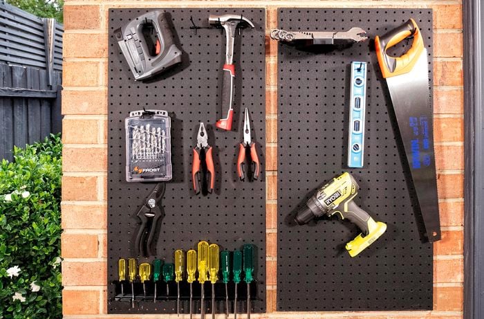Pegboard with tools hanging off it.