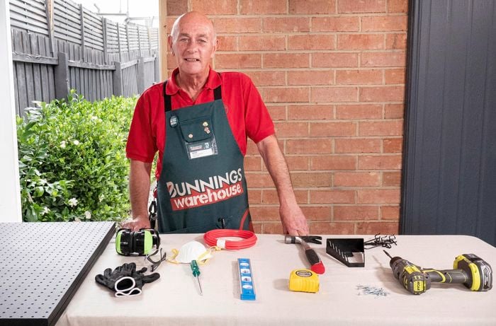 Person standing with their pegboard, spirit level, safety equipment, screwdriver and various other tools.