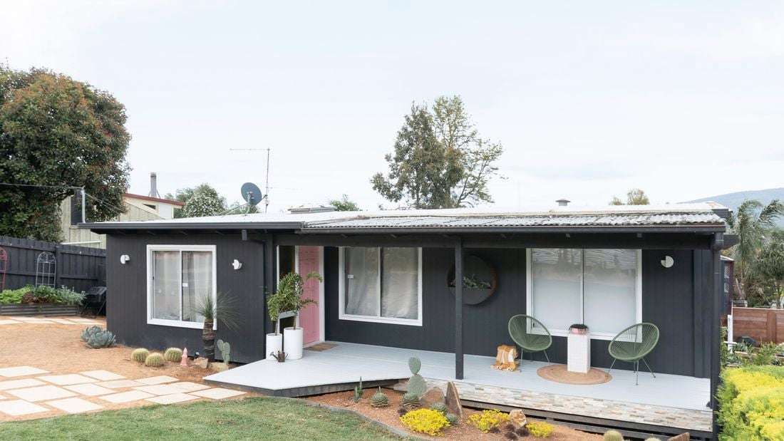 Front yard after transformation image of painted weatherboard house and manicured front lawn
