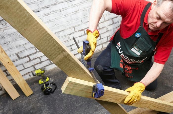 Person clamping two pieces of timber together.