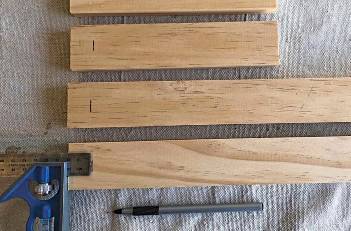 Lengths of pine board with measurements marked and a set square and pencil
