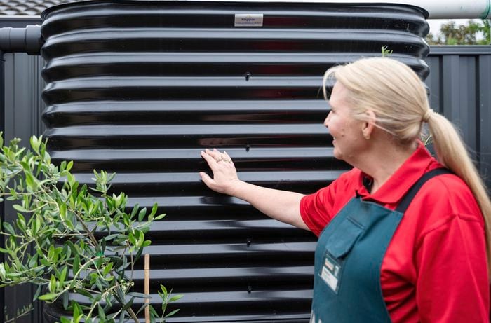 Bunnings team member touching the water tank