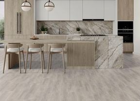 Modern kitchen with vinyl flooring, light wood cabinetry, a large island with seating, marble splashback and pendant lights.