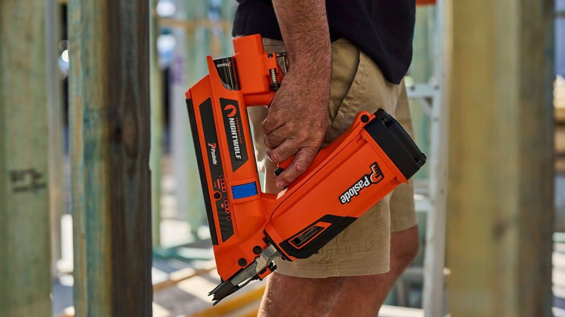 A man shot from the waist down holds the Paslode FrameMaster NightWolf on a construction site.