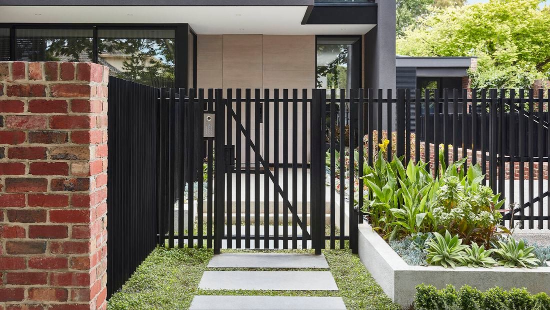 red brick house with black metal fence